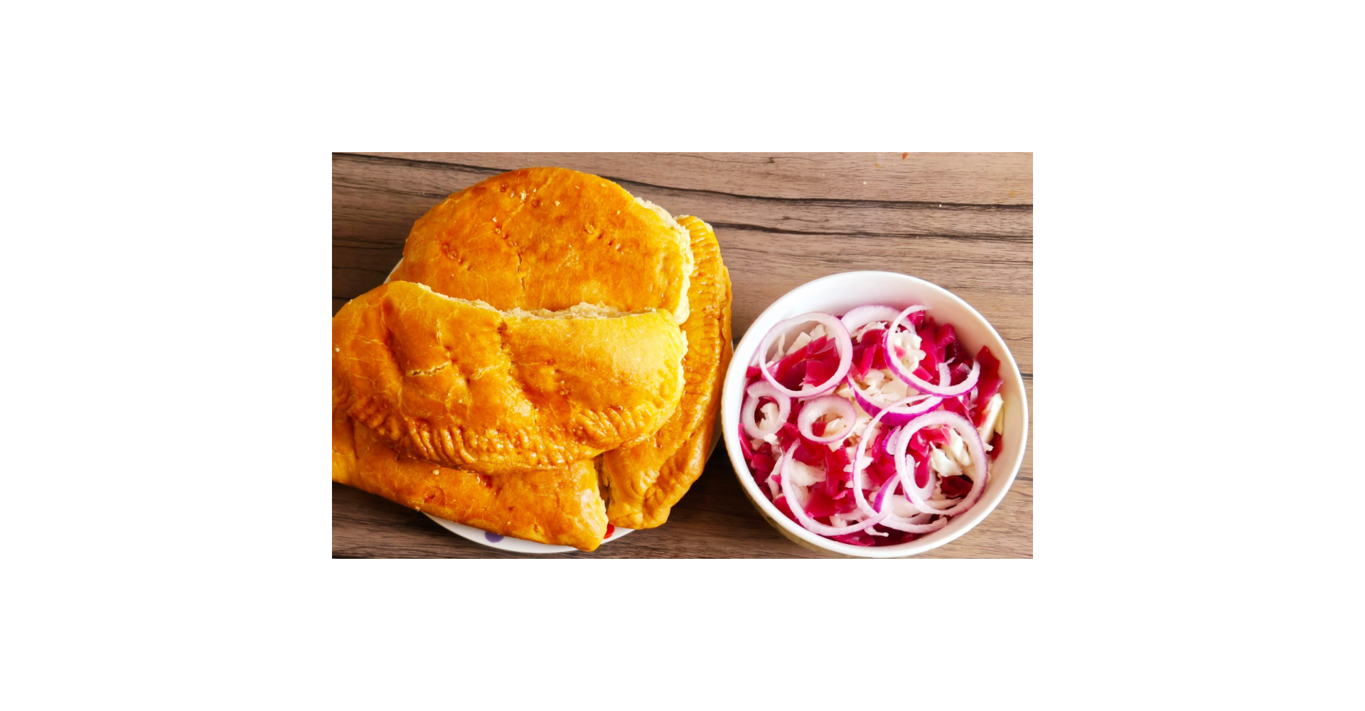 A plate of Jamaican paties on the left and on the right a colourful salad