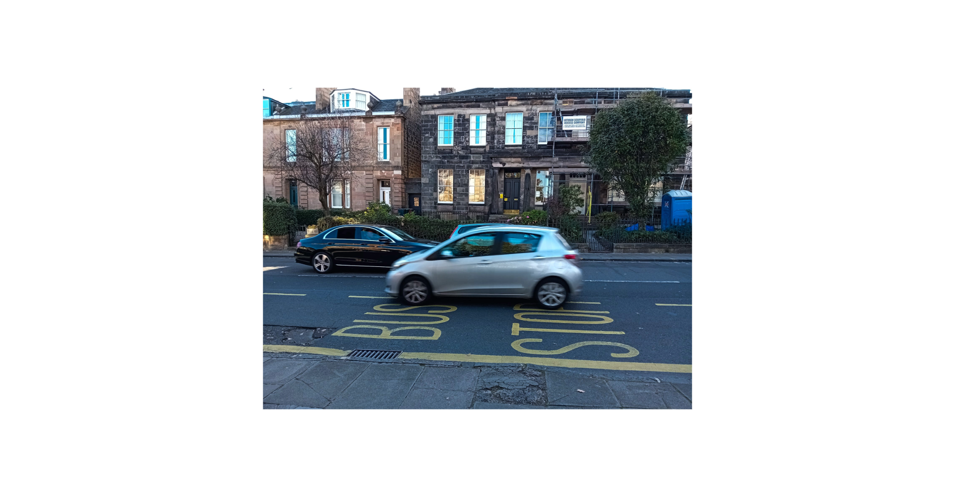 A silver car driving past at speed